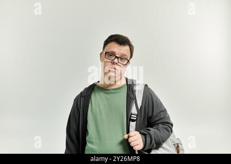 Ein junger Mann mit Down-Syndrom steht nachdenklich bereit für eine neue Reise. Stockfoto