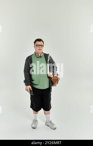 Ein junger Mann mit Down-Syndrom steht zuversichtlich zu Hause, bereit für ein Abenteuer. Stockfoto