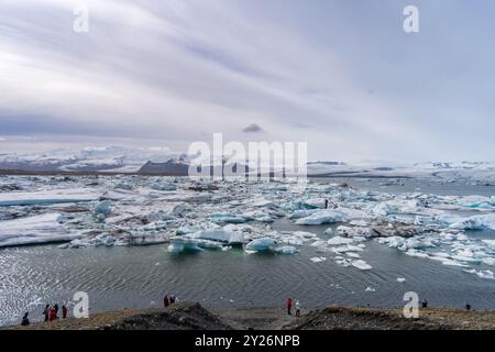 Blau-weiße Eisberge schweben in einem Gletschersee vor dem Hintergrund von Gletschern und schaffen eine ruhige Szene. Unberührtes Jokulsarlon, Island. Stockfoto