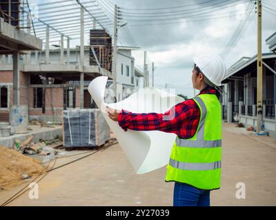 Ingenieure, die Baupläne im Außenbereich mit Bauplänen auf einer Baustelle durchführen, Ingenieurkonzept und Architekturkonzept, Ingenieurarbeit Stockfoto