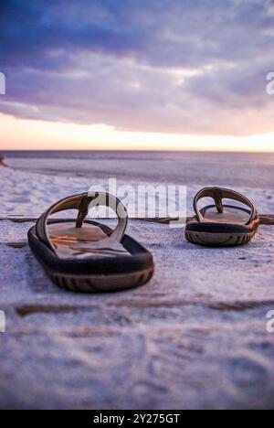 Flipflops an einem Sandstrand Stockfoto