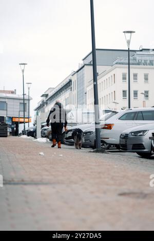 Frau, die im Herbst auf Gehsteig in Rovaniemi, Lappland, unterwegs ist Stockfoto