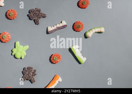 Bunte Auswahl an gummiartigen Halloween-Bonbons auf grauem Hintergrund Stockfoto