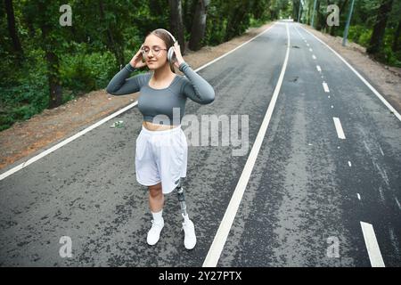 Eine entschlossene Frau mit einer Beinprothese umarmt die Natur, trainiert und genießt die frische Luft. Stockfoto