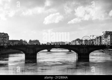 Schwarz-weiß. Blick auf den Fluss Arno mit Ponte Santa Trinita, voller Menschen am Ostermontag, Florenz, Toskana, Italien Stockfoto