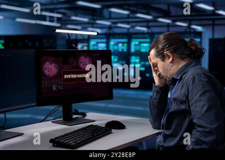 Techniker im Server-Hub, der eine Handbewegung ausführt und versucht, die Hardware vor dem Diebstahl von Informationen durch Hacker zu schützen. Verärgerter Mitarbeiter im Rechenzentrum, der durch Viren verursachte Sicherheitsverletzungen überfordert wird Stockfoto