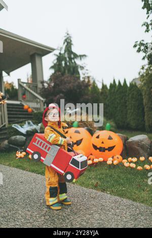 Ein kleiner Junge in einem selbstgemachten Feuerwehrkostüm. Stockfoto