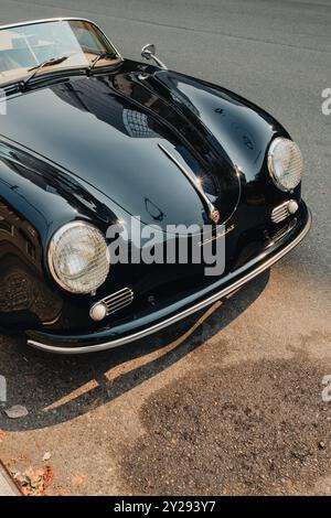 Scheinwerfer mit Gitterabdeckungen am geparkten schwarzen Porsche Cabriolet Stockfoto
