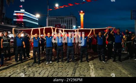 Izmir, Türkei. September 2024. Der Jahrestag der Befreiung von Izmir am 9. September, ein wichtiges Datum im türkischen Unabhängigkeitskrieg. Bei der Veranstaltung, bei der der 102. Jahrestag der Befreiung Izmirs von der feindlichen Besatzung gefeiert wurde, wurde eine 350 Meter hohe türkische Flagge von den Menschen getragen, die an der Fackelprozession teilnahmen. Quelle: İdil Toffolo/Alamy Live News Stockfoto