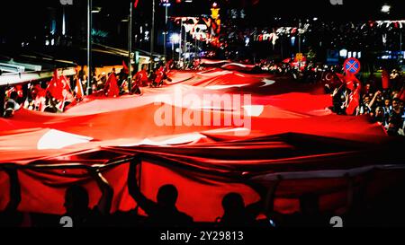 Izmir, Türkei. September 2024. Der Jahrestag der Befreiung von Izmir am 9. September, ein wichtiges Datum im türkischen Unabhängigkeitskrieg. Bei der Veranstaltung, bei der der 102. Jahrestag der Befreiung Izmirs von der feindlichen Besatzung gefeiert wurde, wurde eine 350 Meter hohe türkische Flagge von den Menschen getragen, die an der Fackelprozession teilnahmen. Quelle: İdil Toffolo/Alamy Live News Stockfoto