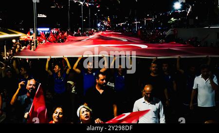 Izmir, Türkei. September 2024. Der Jahrestag der Befreiung von Izmir am 9. September, ein wichtiges Datum im türkischen Unabhängigkeitskrieg. Bei der Veranstaltung, bei der der 102. Jahrestag der Befreiung Izmirs von der feindlichen Besatzung gefeiert wurde, wurde eine 350 Meter hohe türkische Flagge von den Menschen getragen, die an der Fackelprozession teilnahmen. Quelle: İdil Toffolo/Alamy Live News Stockfoto