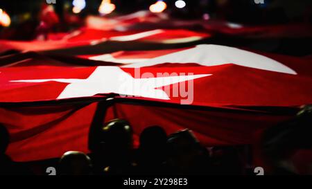 Izmir, Türkei. September 2024. Der Jahrestag der Befreiung von Izmir am 9. September, ein wichtiges Datum im türkischen Unabhängigkeitskrieg. Bei der Veranstaltung, bei der der 102. Jahrestag der Befreiung Izmirs von der feindlichen Besatzung gefeiert wurde, wurde eine 350 Meter hohe türkische Flagge von den Menschen getragen, die an der Fackelprozession teilnahmen. Quelle: İdil Toffolo/Alamy Live News Stockfoto