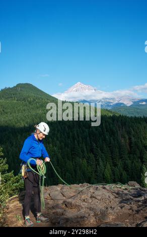 Ein weibliches Senior-Weibchen windet ein Kletterseil auf dem Gipfel des French's Dome unterhalb des Mt Hood in Oregon. USA Stockfoto