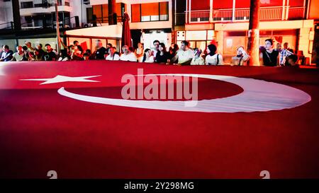 Izmir, Türkei. September 2024. Der Jahrestag der Befreiung von Izmir am 9. September, ein wichtiges Datum im türkischen Unabhängigkeitskrieg. Bei der Veranstaltung, bei der der 102. Jahrestag der Befreiung Izmirs von der feindlichen Besatzung gefeiert wurde, wurde eine 350 Meter hohe türkische Flagge von den Menschen getragen, die an der Fackelprozession teilnahmen. Quelle: İdil Toffolo/Alamy Live News Stockfoto