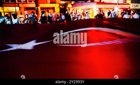 Izmir, Türkei. September 2024. Der Jahrestag der Befreiung von Izmir am 9. September, ein wichtiges Datum im türkischen Unabhängigkeitskrieg. Bei der Veranstaltung, bei der der 102. Jahrestag der Befreiung Izmirs von der feindlichen Besatzung gefeiert wurde, wurde eine 350 Meter hohe türkische Flagge von den Menschen getragen, die an der Fackelprozession teilnahmen. Quelle: İdil Toffolo/Alamy Live News Stockfoto