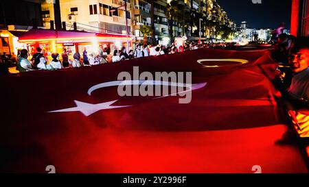 Izmir, Türkei. September 2024. Der Jahrestag der Befreiung von Izmir am 9. September, ein wichtiges Datum im türkischen Unabhängigkeitskrieg. Bei der Veranstaltung, bei der der 102. Jahrestag der Befreiung Izmirs von der feindlichen Besatzung gefeiert wurde, wurde eine 350 Meter hohe türkische Flagge von den Menschen getragen, die an der Fackelprozession teilnahmen. Quelle: İdil Toffolo/Alamy Live News Stockfoto