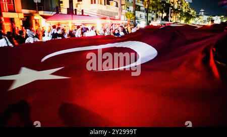 Izmir, Türkei. September 2024. Der Jahrestag der Befreiung von Izmir am 9. September, ein wichtiges Datum im türkischen Unabhängigkeitskrieg. Bei der Veranstaltung, bei der der 102. Jahrestag der Befreiung Izmirs von der feindlichen Besatzung gefeiert wurde, wurde eine 350 Meter hohe türkische Flagge von den Menschen getragen, die an der Fackelprozession teilnahmen. Quelle: İdil Toffolo/Alamy Live News Stockfoto