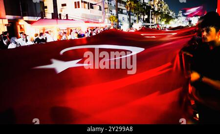 Izmir, Türkei. September 2024. Der Jahrestag der Befreiung von Izmir am 9. September, ein wichtiges Datum im türkischen Unabhängigkeitskrieg. Bei der Veranstaltung, bei der der 102. Jahrestag der Befreiung Izmirs von der feindlichen Besatzung gefeiert wurde, wurde eine 350 Meter hohe türkische Flagge von den Menschen getragen, die an der Fackelprozession teilnahmen. Quelle: İdil Toffolo/Alamy Live News Stockfoto