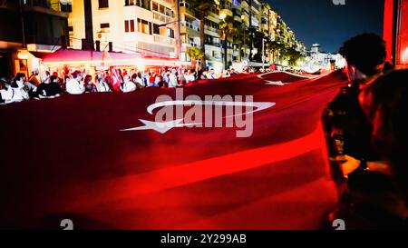 Izmir, Türkei. September 2024. Der Jahrestag der Befreiung von Izmir am 9. September, ein wichtiges Datum im türkischen Unabhängigkeitskrieg. Bei der Veranstaltung, bei der der 102. Jahrestag der Befreiung Izmirs von der feindlichen Besatzung gefeiert wurde, wurde eine 350 Meter hohe türkische Flagge von den Menschen getragen, die an der Fackelprozession teilnahmen. Quelle: İdil Toffolo/Alamy Live News Stockfoto