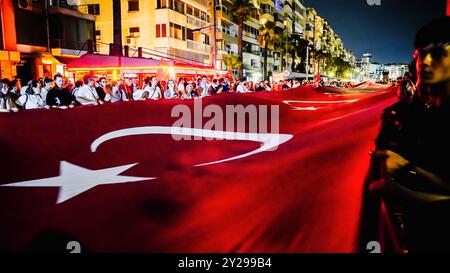 Izmir, Türkei. September 2024. Der Jahrestag der Befreiung von Izmir am 9. September, ein wichtiges Datum im türkischen Unabhängigkeitskrieg. Bei der Veranstaltung, bei der der 102. Jahrestag der Befreiung Izmirs von der feindlichen Besatzung gefeiert wurde, wurde eine 350 Meter hohe türkische Flagge von den Menschen getragen, die an der Fackelprozession teilnahmen. Quelle: İdil Toffolo/Alamy Live News Stockfoto