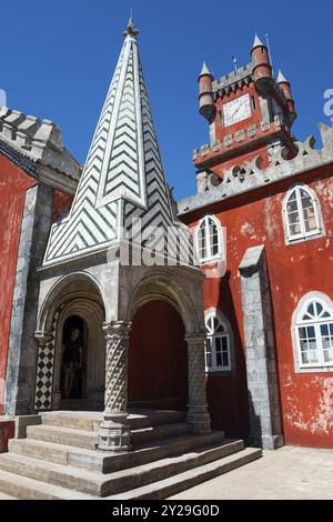 Roter Turm mit Uhr und Kirche mit spitzem Dach und Stufen und Fenstern, architektonisch historisch, Palacio Nacional da Pena, Pena National Palace, Sin Stockfoto