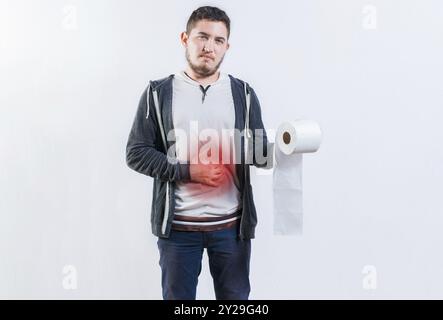 Person mit Durchfall und Magenproblemen, die Toilettenpapier hält. Mann mit Magenschmerzen, der Papierrolle isoliert hält Stockfoto