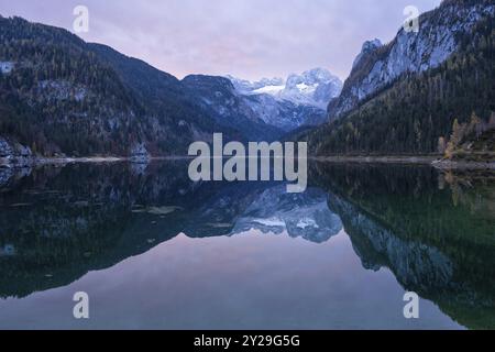 Der vordere Gosausee im Herbst mit Blick auf die Dachsteinkette. Der Gosaukamm ist rechts. Wolken am Himmel, Sonnenaufgang. Vorderer Gosa Stockfoto