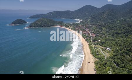 Aus der Vogelperspektive auf das kleine Stranddorf Picinguaba, Inseln und Bucht, wundervolle grüne Küstenlandschaft im Hintergrund, Brasilien, Südamerika Stockfoto