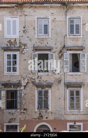 Fenster eines alten Gebäudes mit Einschusslöchern aus dem Balkankrieg. Fenster- oder Hausfront in der historischen Altstadt von Zadar, Adria, D Stockfoto