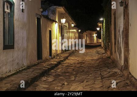 Stimmungsvoller nächtlicher Blick auf die beleuchtete Straße und die Gebäude im historischen Zentrum von Paraty, Brasilien, UNESCO-Weltkulturerbe, Südamerika Stockfoto