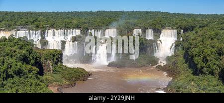 Panoramablick auf die spektakuläre Kaskade der Iguazu-Fälle bei Sonnenschein und braunem Fluss, Argentinien, Südamerika Stockfoto