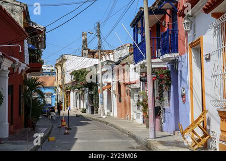 Typische Straße mit traditionellen, farbenfrohen Gebäuden und Stromleitungen an einem sonnigen Tag in der Altstadt, Cartagena, Kolumbien, Südamerika Stockfoto