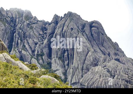 Malerische, zerklüftete Granitberge der Serra da Mantiqueira (Mantiqueira Gebirgskette) mit grasbedeckten Teilen vor hellem Hintergrund, obere Itatiaia, Stockfoto