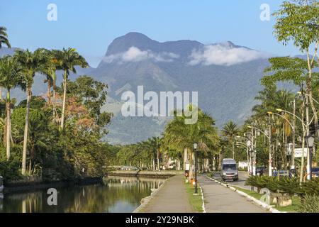 Blick von der Promenade mit Bäumen des Flusses Pereque-ACU auf die majestätischen atlantischen Waldberge im Hintergrund, Paraty, Brasilien, Südamerika Stockfoto