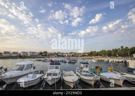 Strand mit kleinem Hafen, morgens. Wunderschöner Sonnenaufgang am Mittelmeer. Mittelmeerküste und Landschaft der Insel Vir, Zadar, D Stockfoto