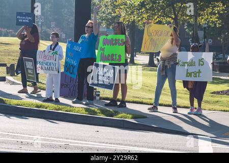 Suwanee, GA / USA - 7. September 2024: Demokratische Parteiaktivisten ermutigen Fahrzeuge, Kamala Harris bei einer lokalen Kampagne zu hupen. Stockfoto