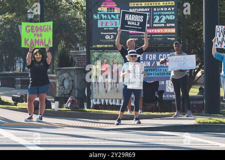 Suwanee, GA / USA - 7. September 2024: Demokratische Parteiaktivisten ermutigen Fahrzeuge, Kamala Harris bei einer lokalen Kampagne zu hupen. Stockfoto