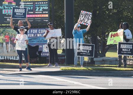 Suwanee, GA / USA - 7. September 2024: Demokratische Aktivisten ermutigen Fahrzeuge, bei einer lokalen Veranstaltung „Honk for Kamala Harris“ die Hörner zu blasen. Stockfoto