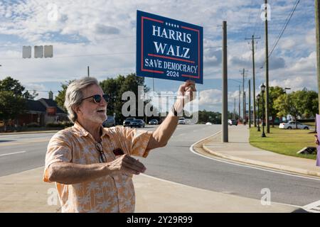 Lawrenceville, GA/USA - 5. September 2024: Ein Mann hält begeistert ein Wahlkampfschild für Kamala Harris bei einem lokalen Honk for Harris Event. Stockfoto