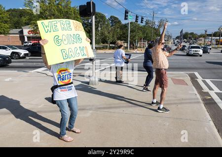 Lawrenceville, GA/USA - 5. September 2024: Menschen halten begeistert Kampagnenschilder für Kamala Harris bei einer lokalen Veranstaltung „Honk for Harris“. Stockfoto