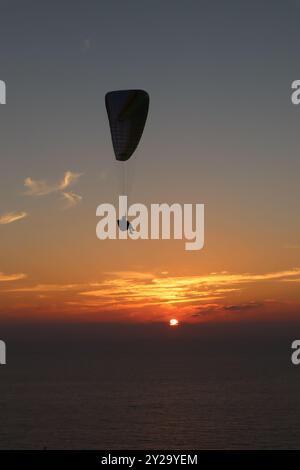 Silhouette eines Gleitschirms bei Sonnenuntergang mit roter Sonne bei Torrey Pines San Diego Stockfoto