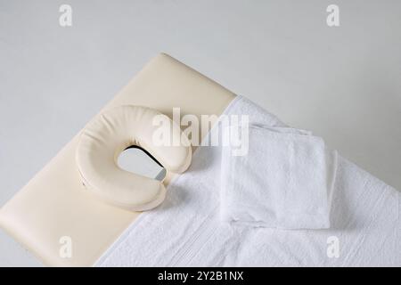 Massagetisch mit Blick auf weißen Hintergrund, Massagetherapeut Arbeitsplatz, Massagekonzept Stockfoto