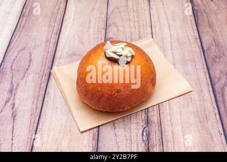 Köstliche, handwerkliche Brötchen gefüllt mit dunkler Schokolade, frisch gebacken auf einer Reihe von lebensmittelbeständigem Papier Stockfoto