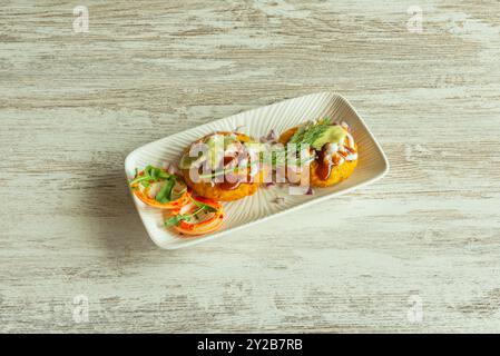 Eine typische indische Vorspeise im Restaurant mit Zwiebeln, Saucen und Gewürzen auf einem weißen Teller Stockfoto