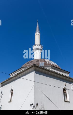 Das Kuppeldach und Minarett der Maksut Pascha (Marash) Moschee im Zentrum von Prizren im Kosovo an einem sonnigen Tag mit blauem Himmel und ohne Wolken oder Menschen. Stockfoto