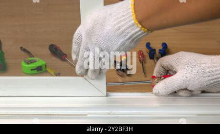 Bauarbeiter, der das Schiebefenster repariert. Stockfoto