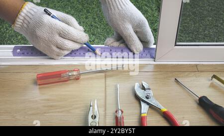 Bauarbeiter, der das Schiebefenster repariert. Stockfoto