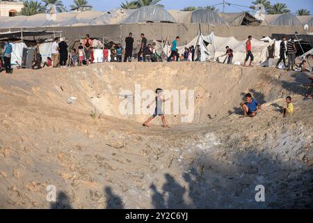 Gaza, Gaza, Palästina. September 2024. Palästinenser suchen nach vermissten Menschen unter den Trümmern, nachdem israelische Luftangriffe mehr als 15 Menschen getötet haben, in einem Lager für Vertriebene im Gebiet von Al-Mawasi, das die israelische Besatzungsarmee am 10. September 2024 als Sicherheitszone in Khan Yunis im südlichen Gazastreifen ausgewiesen hat. (Kreditbild: © Saher Alghorra/ZUMA Press Wire) NUR REDAKTIONELLE VERWENDUNG! Nicht für kommerzielle ZWECKE! Stockfoto