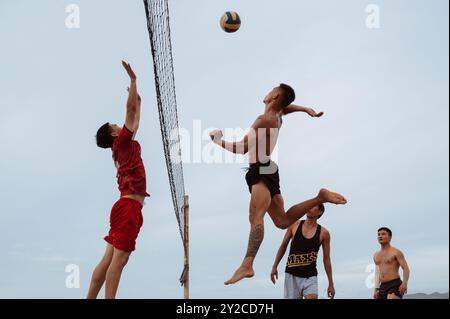 Asiatische vietnamesische Spieler spielen Beachvolleyball an einem Sandstrand am Meer während des Sommertages in Nha Trang. Nha Trang, Vietnam - 21. Juli 2024 Stockfoto