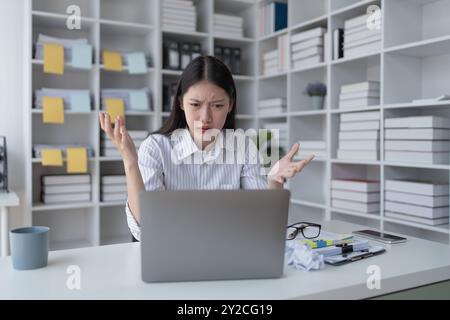 Geschäftsfrau plant eine Finanzprüfung, prüft Dokumente, während sie gegen das Burnout-Syndrom kämpft Stockfoto